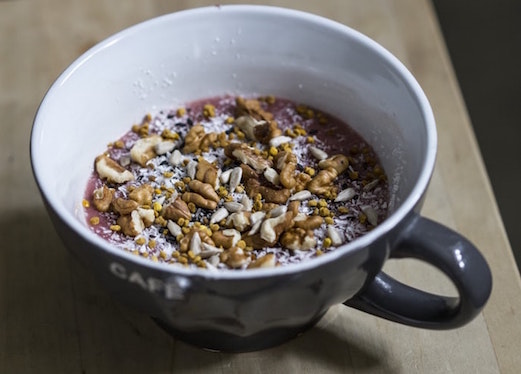 Image of seeds, nuts and blended berries in a coffee cup